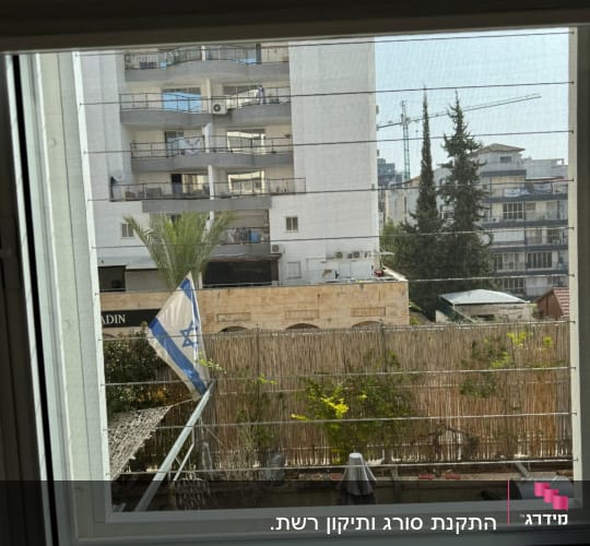 חלון אלומיניום עם נוף עירוני ברקע